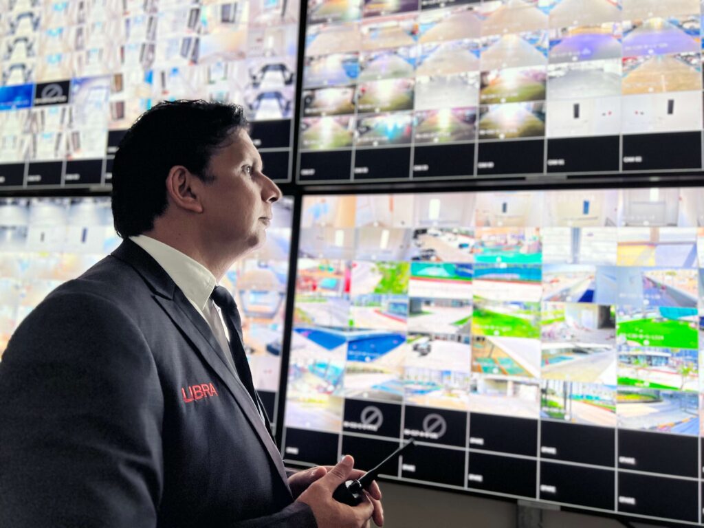 Libra security guard monitoring CCTV footage as part of residential security guard services in the UAE.