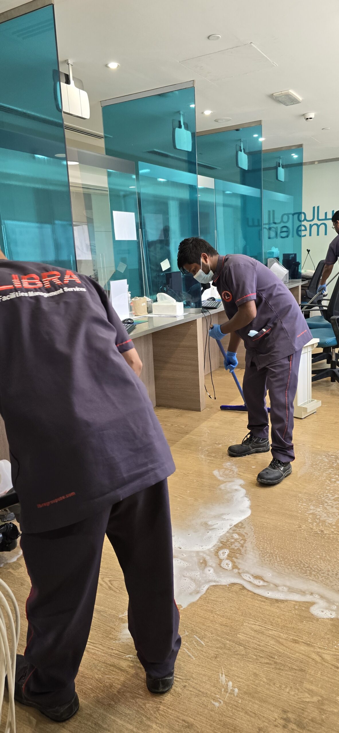 Libra Group expert cleaning services Dubai – professional cleaner mopping an office floor for a spotless workspace.